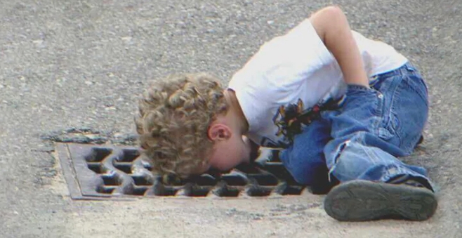 Un garçon fond en larmes après avoir fait tomber le cadeau de sa mère dans les égouts, un sans abri lui vient en aide   Histoire du jour